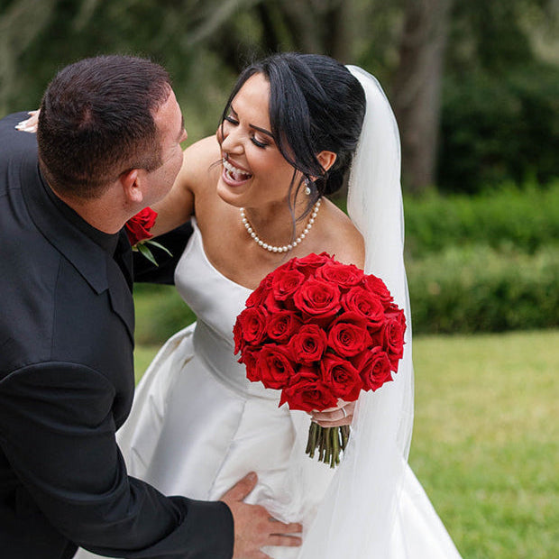 Romantic bride holding a bouquet of ivory and blush roses during a wedding ceremony, showcasing elegant rose floral design for wedding bouquet preservation.