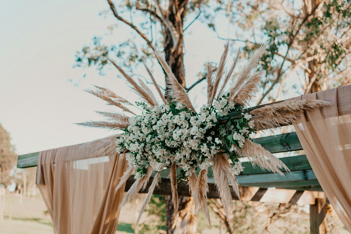 Elegant brown wedding bouquet with earthy roses, dried florals, and silk ribbon, styled for a warm, modern wedding and preserved as a timeless floral keepsake.
