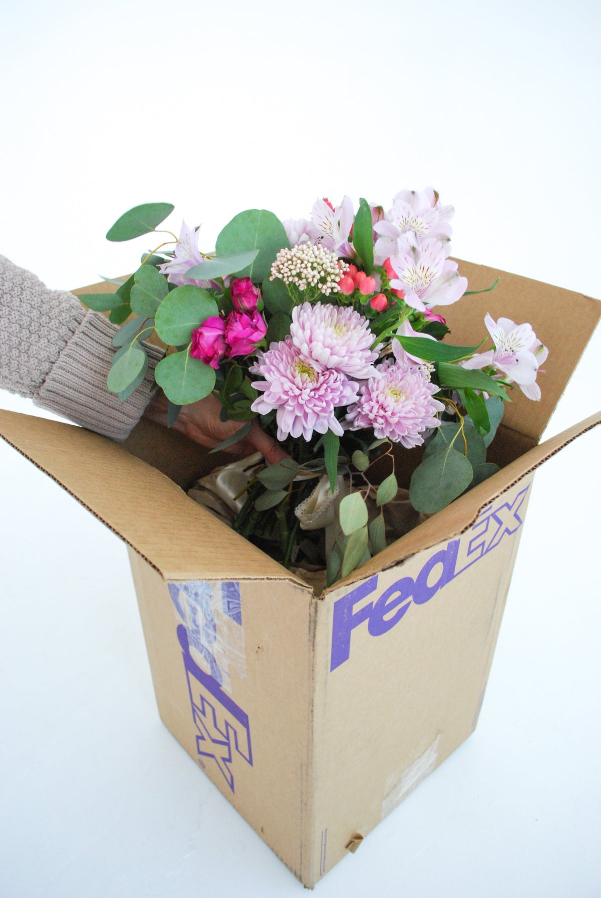 Bride transporting wedding bouquet and floral arrangements in a temperature-controlled vehicle, protecting fresh wedding flowers for ceremony setup and future floral preservation keepsakes.