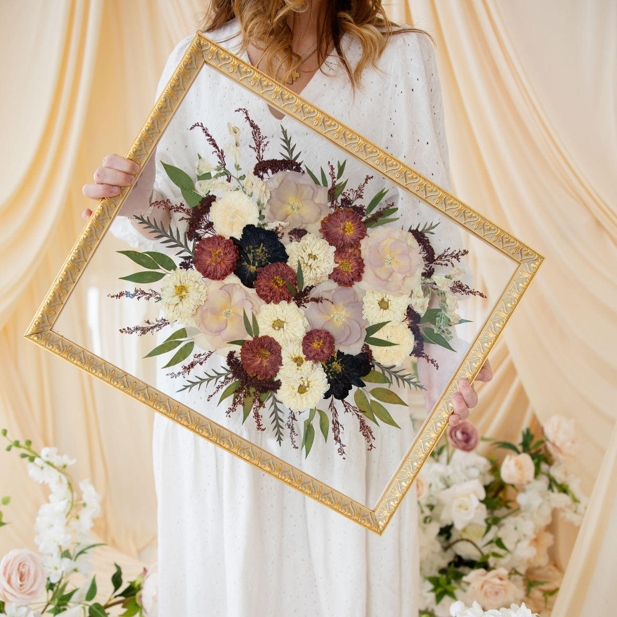 Pressed floral frame preserving ivory roses, burgundy chrysanthemums, blush roses, dried grasses, eucalyptus, and botanical greenery, handcrafted by Blossom & Rhyme