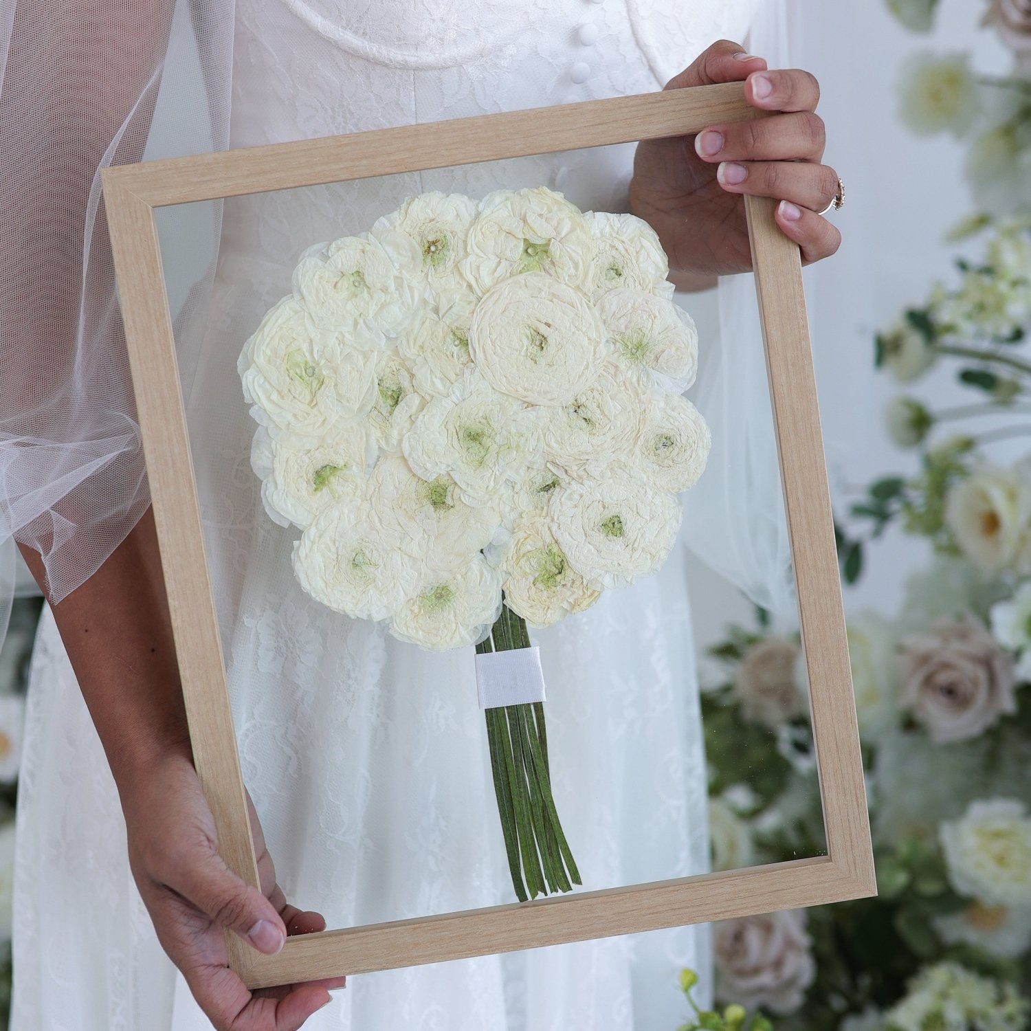All white rose bouquet preserved in glass with simple frame.