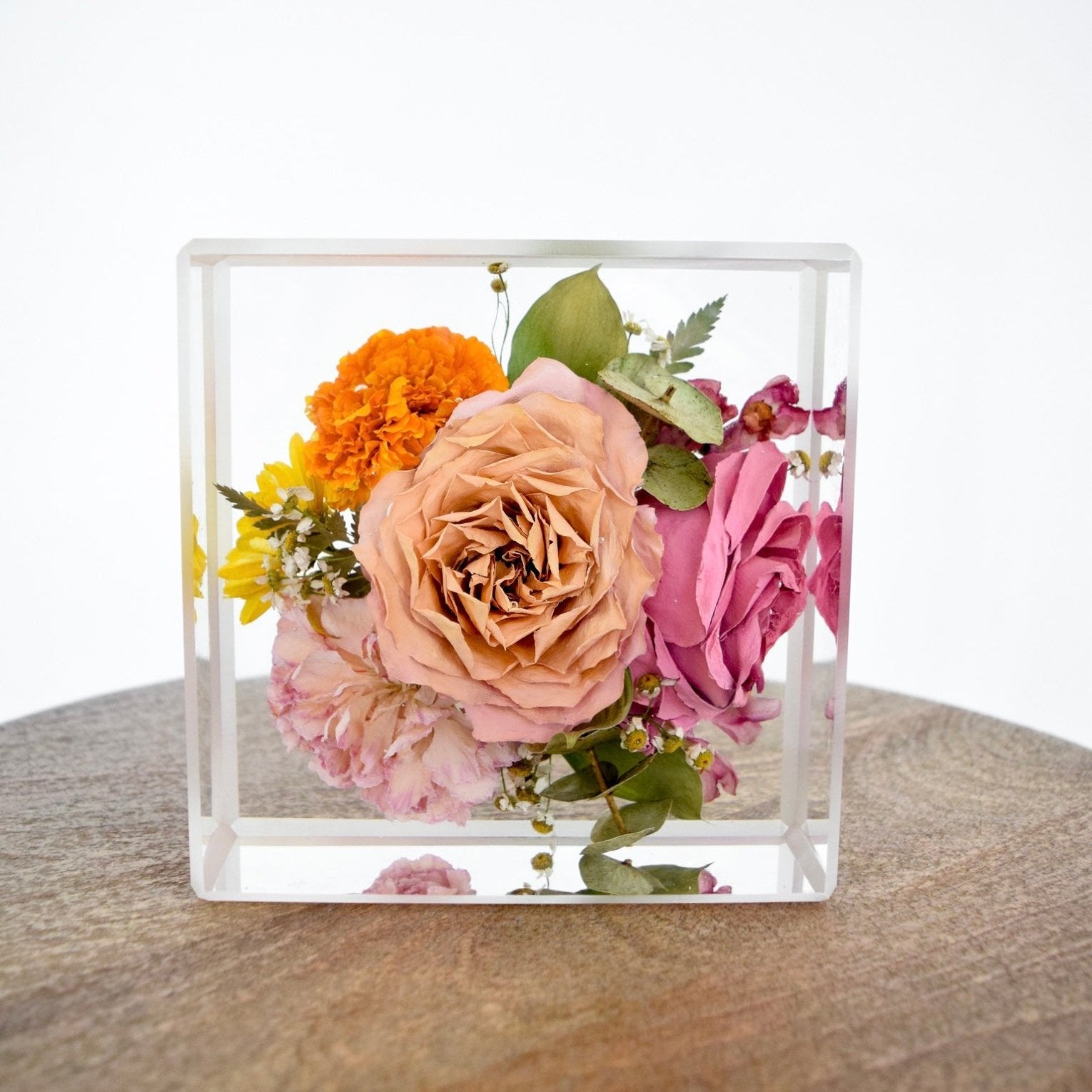 6x6 Resin Floral Block preserving a blush garden rose, pink rose, orange marigold, pink carnation, yellow daisy, eucalyptus, and delicate botanical accents in clear resin, handcrafted by Blossom & Rhymeblossomandrhyme