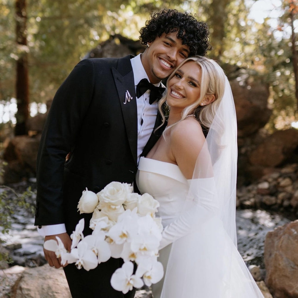 Bride and groom holding a white wedding bouquet before flower preservation by Blossom & Rhyme