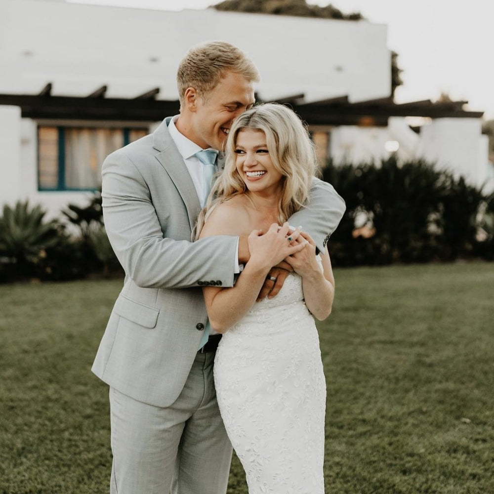 Bride and groom embracing on their wedding day before preserving their bouquet with Blossom & Rhyme