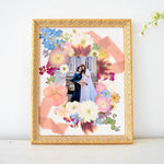 Custom pressed floral photo frame featuring preserved blue hydrangeas, cosmos, daisies, ranunculus, orchids, eucalyptus, and a cherished wedding photo, handcrafted by Blossom & Rhyme