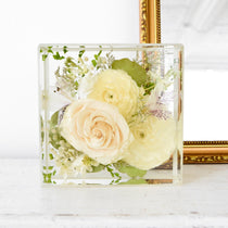 Preserved wedding flowers in resin block for home decor.