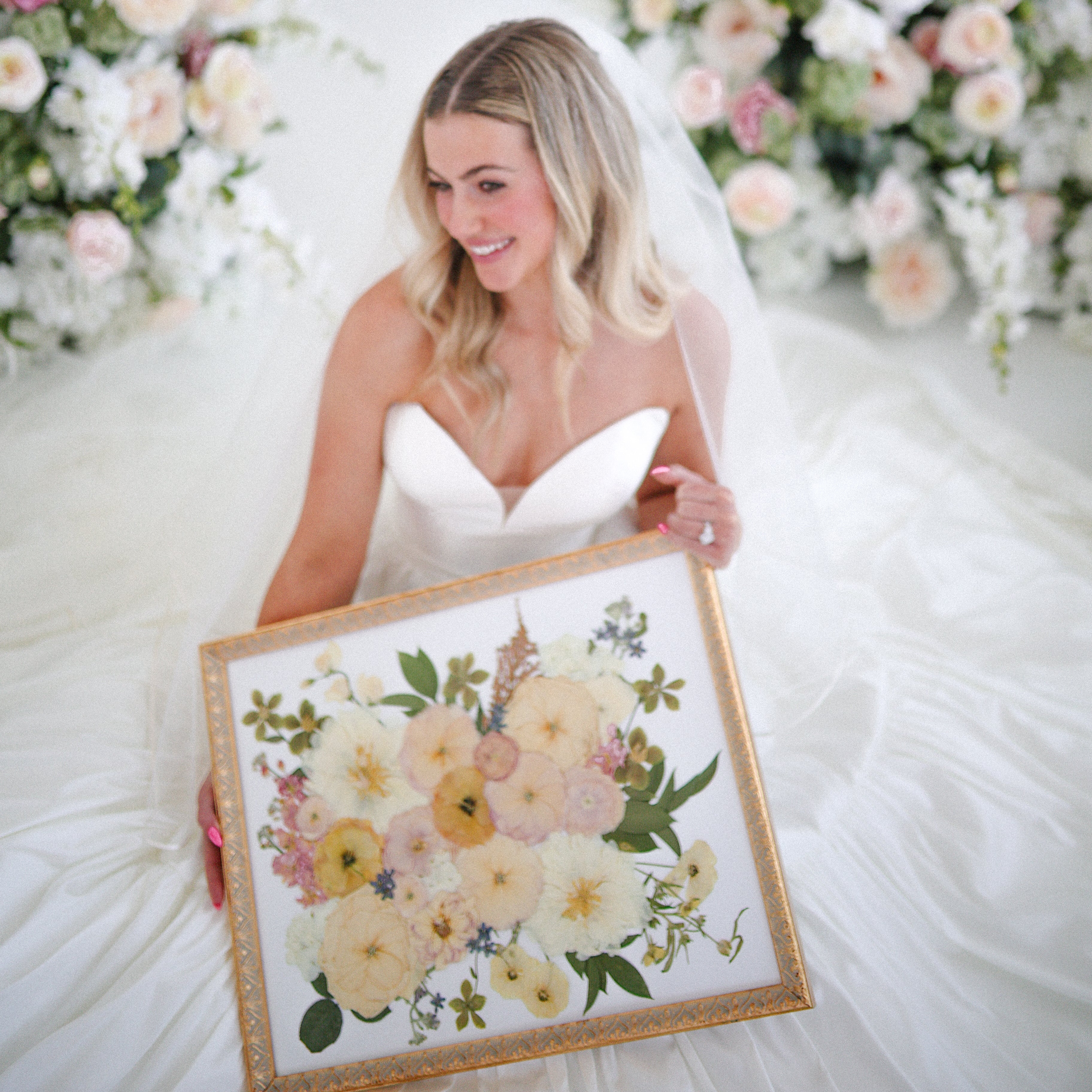 Soft pastel bridal flowers carefully pressed and arranged in frame.