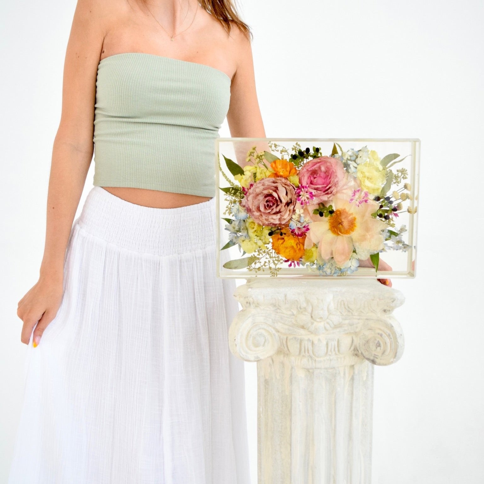 Girl with a 13x9 large floral rectangle preserving blush roses, pastel blooms, and delicate greenery in clear resin, handcrafted by Blossom & Rhyme