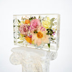 Large floral rectangle preserving blush garden roses, peach cosmos, yellow ranunculus, blue hydrangeas, white hydrangeas, eucalyptus, wax flowers, and seasonal greenery in clear resin, handcrafted by Blossom & Rhyme