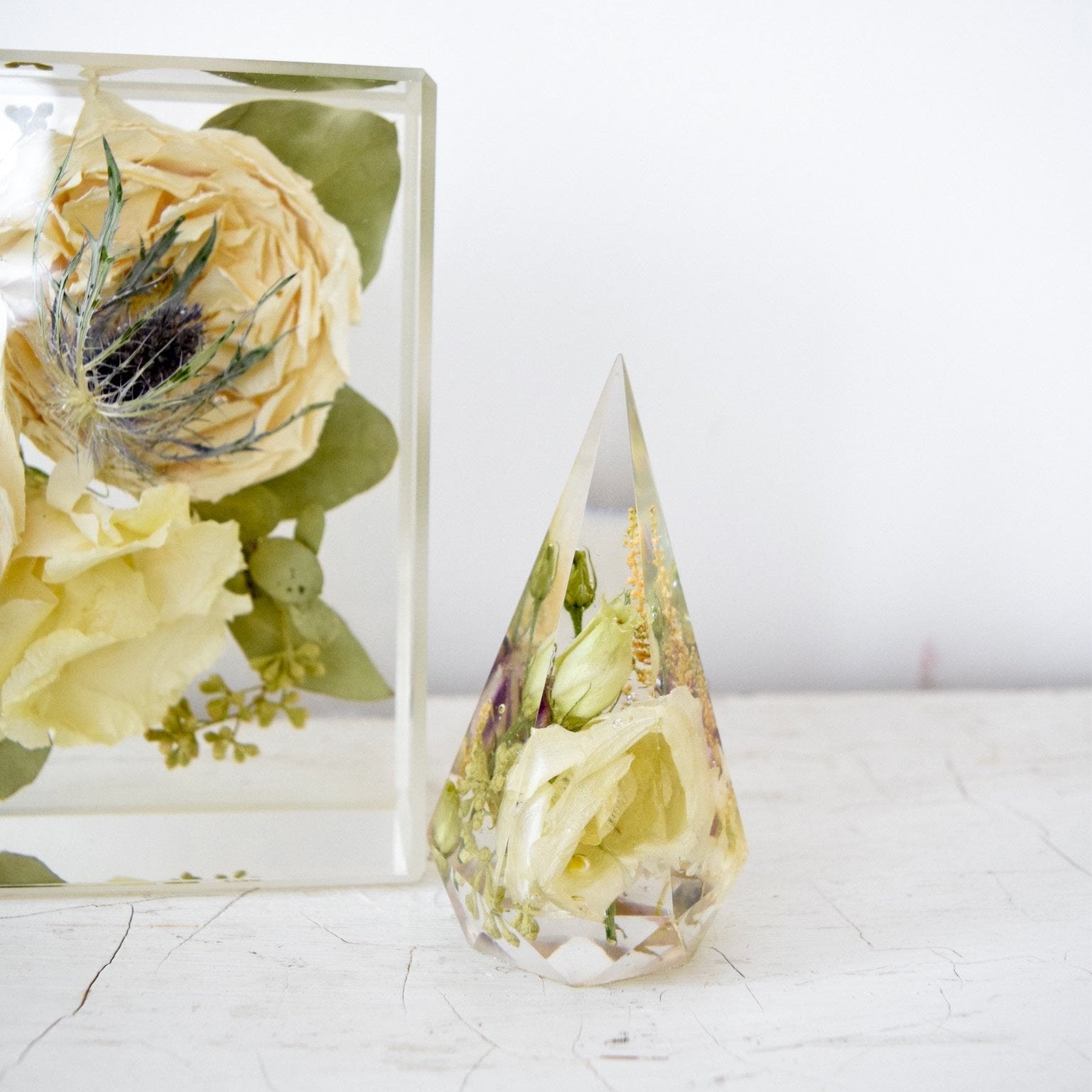 Faceted resin floral keepsake preserving ivory roses, ranunculus, blue thistle, eucalyptus, and delicate botanical accents, handcrafted by Blossom & Rhyme
