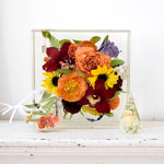 Resin floral keepsake collection featuring a large resin floral block, custom floral ornament, and faceted floral keepsake preserving orange garden roses, burgundy orchids, yellow sunflowers, purple hydrangeas, ranunculus, fern fronds, and botanical greenery, handcrafted by Blossom & Rhyme