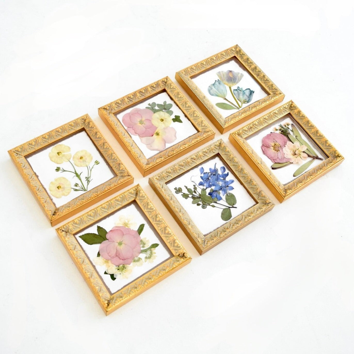 Set of six floral keepsake frames preserving wedding bouquet flowers in a coordinated collage display.
