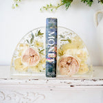 Small resin bookends preserving blush garden roses, ivory roses, white ranunculus, hydrangeas, baby's breath, eucalyptus, and botanical greenery in clear resin, handcrafted by Blossom & Rhyme