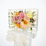 Large floral rectangle preserving blush garden roses, peach cosmos, yellow ranunculus, blue hydrangeas, white hydrangeas, eucalyptus, wax flowers, and seasonal greenery in clear resin, handcrafted by Blossom & Rhyme
